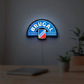 Brugal LED lightbox hanging on a room wall with soft blue light