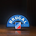 Front view of Brugal LED lightbox sign glowing on a wooden desk