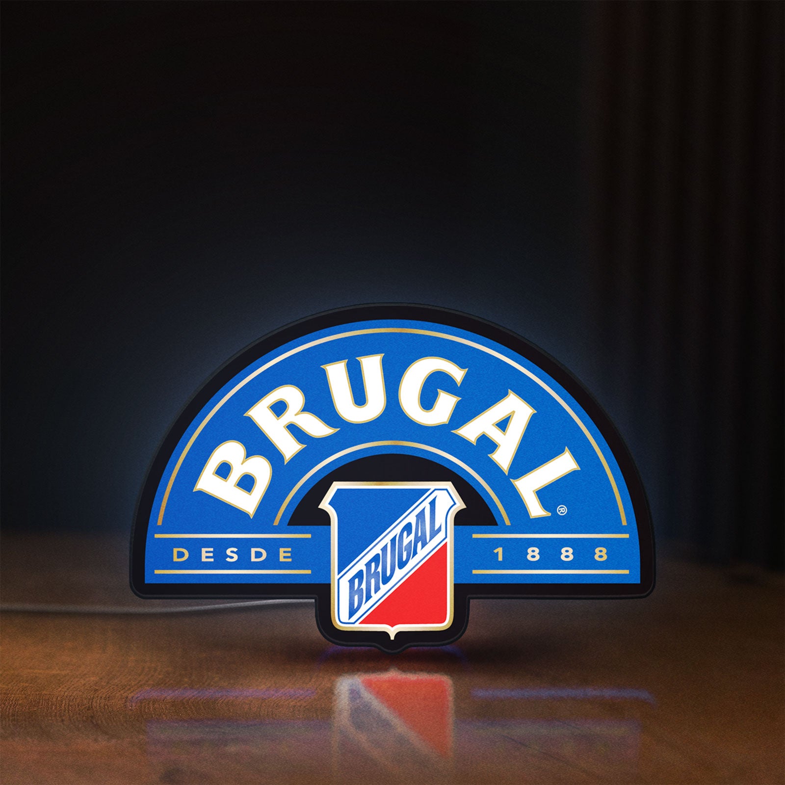Front view of Brugal LED lightbox sign glowing on a wooden desk