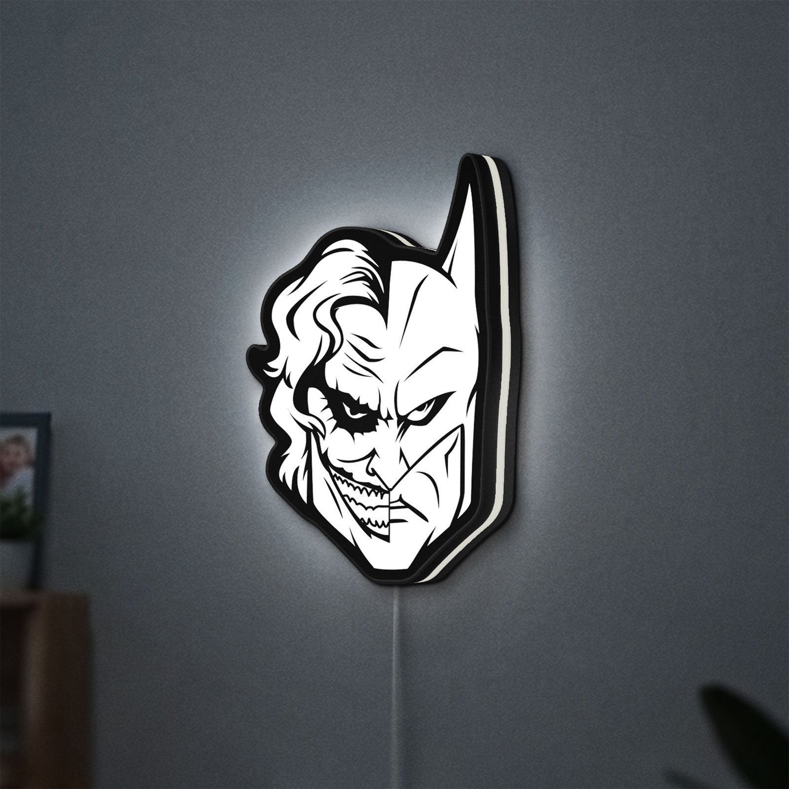 Joker LED lightbox hanging on a wall with white glow