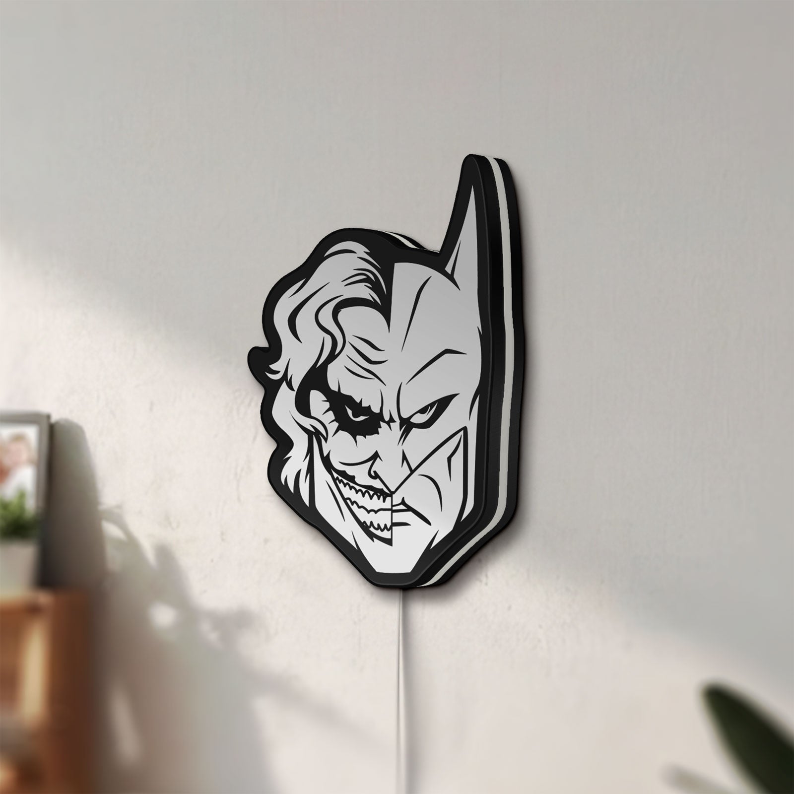 Unlit Joker LED lightbox mounted on a wall in daylight