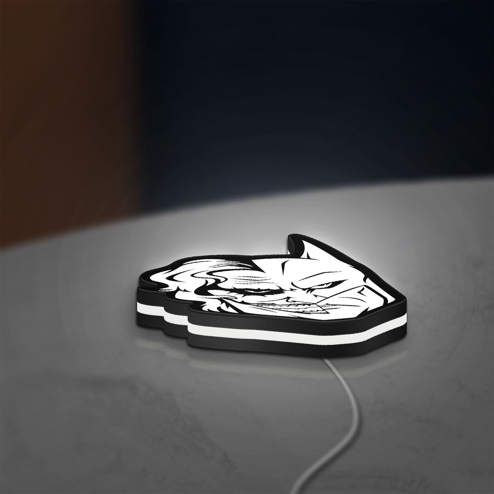 Joker LED lightbox lying flat on a desk with white glow