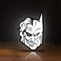 Front view of Joker LED lightbox sign glowing on a wooden desk