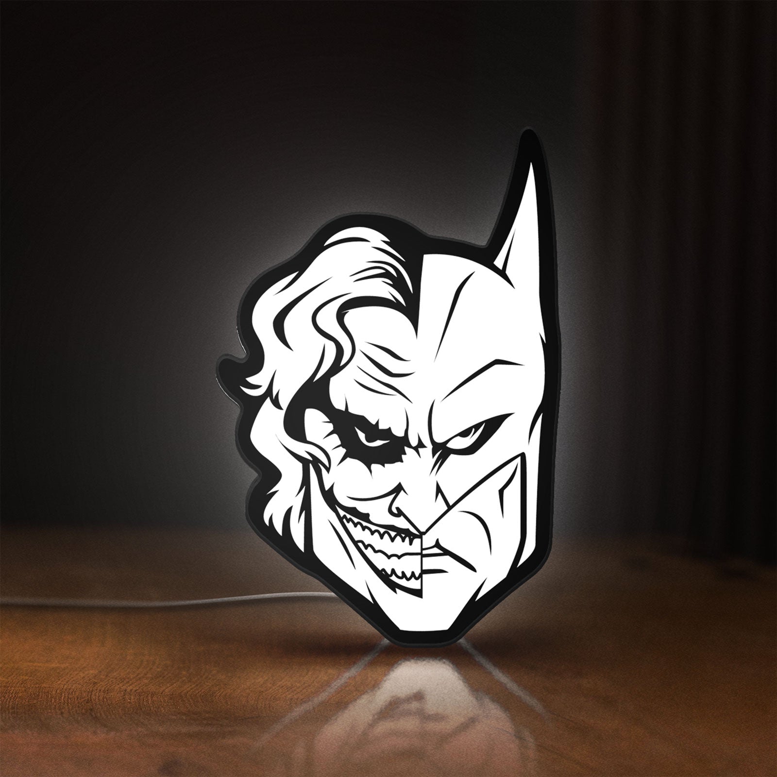Front view of Joker LED lightbox sign glowing on a wooden desk