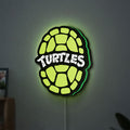Teenage Mutant Ninja Turtles LED lightbox hanging on a wall with green glow