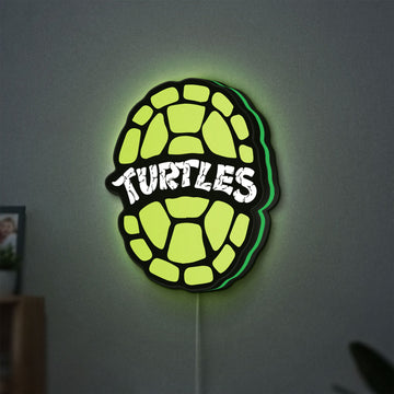 Teenage Mutant Ninja Turtles LED lightbox hanging on a wall with green glow