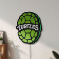 Unlit Teenage Mutant Ninja Turtles LED lightbox mounted on a wall in daylight