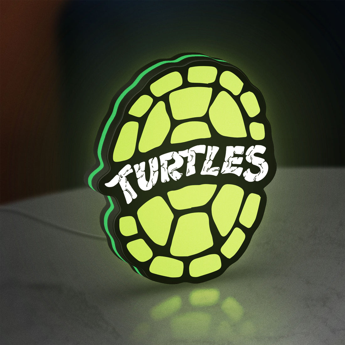 Teenage Mutant Ninja Turtles LED lightbox hanging on a wall with green glow