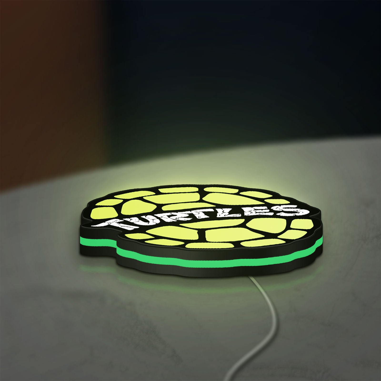 Teenage Mutant Ninja Turtles LED lightbox lying flat on a desk with green glow