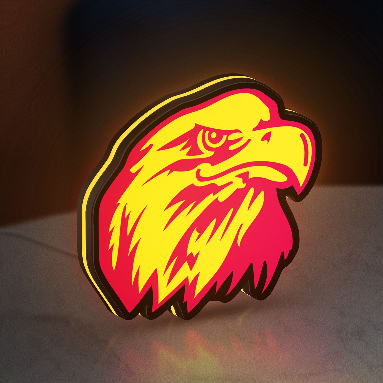 Eagle Head LED lightbox standing on a desk from an angled side view with yellow glow