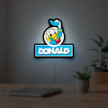Donald LED lightbox hanging on a room wall with soft white light