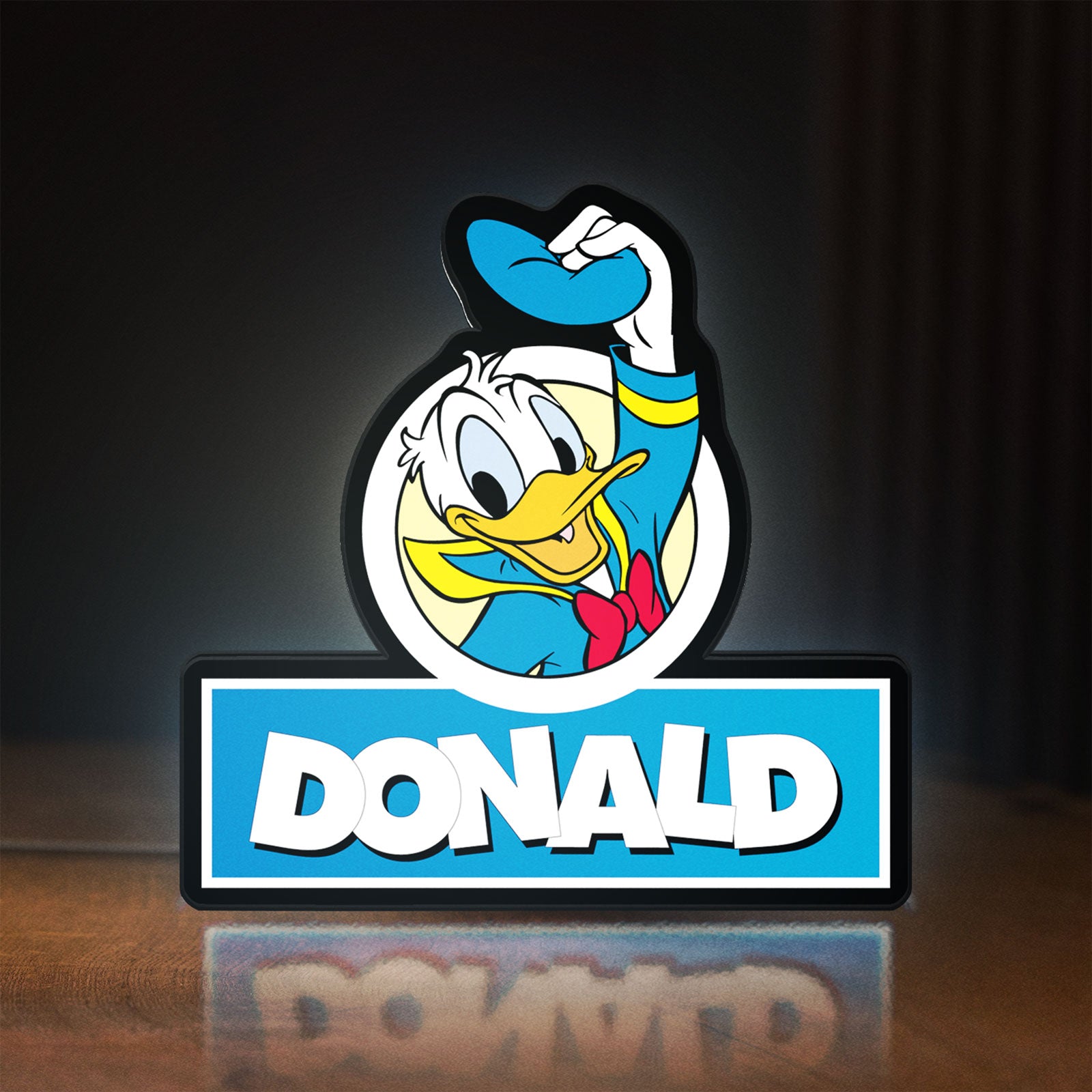 Front view of Donald LED lightbox sign glowing on a wooden desk