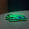 Hulk LED lightbox lying flat on a desk with green glow