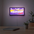 Hollywood Video LED lightbox hanging on a room wall with soft purple light