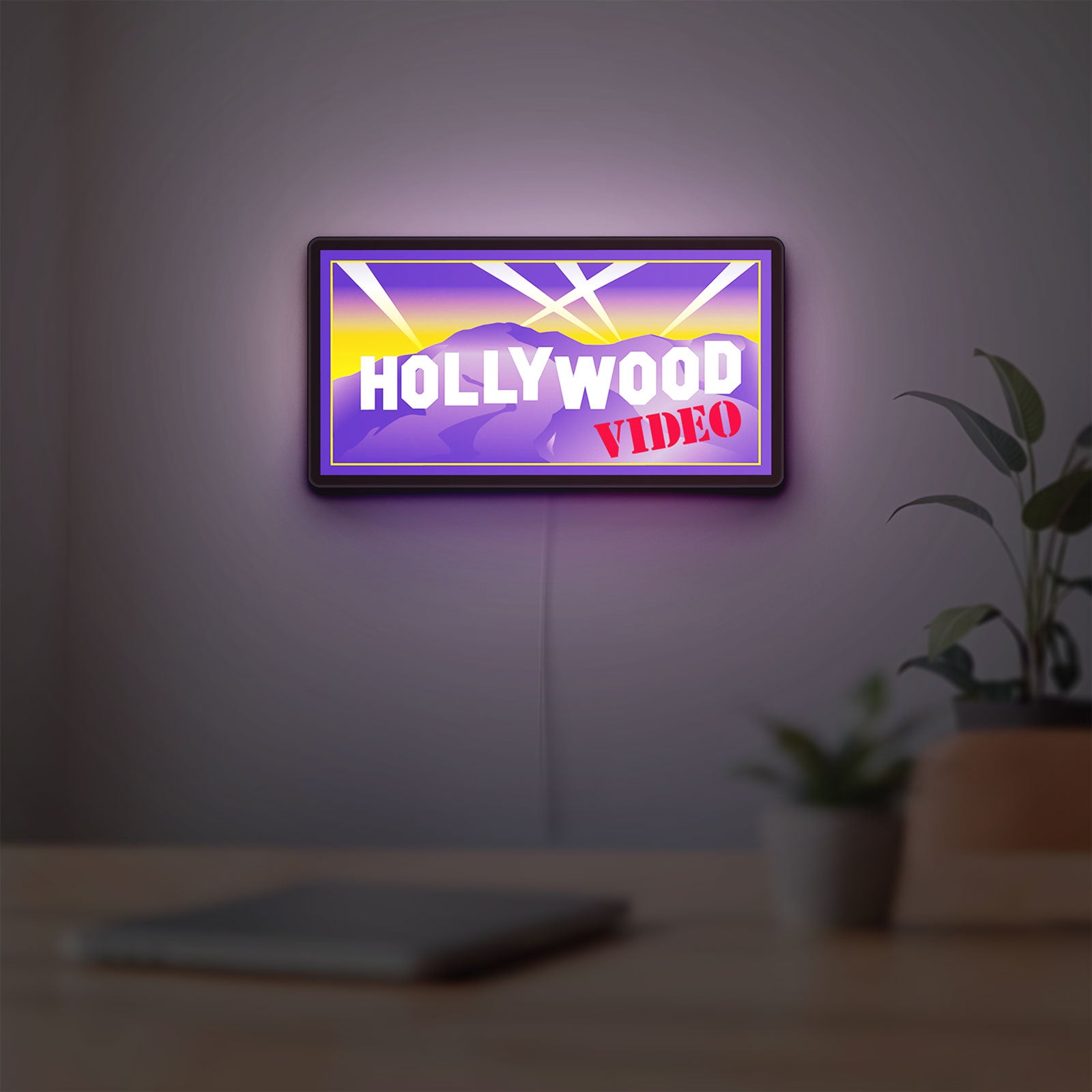 Hollywood Video LED lightbox hanging on a room wall with soft purple light