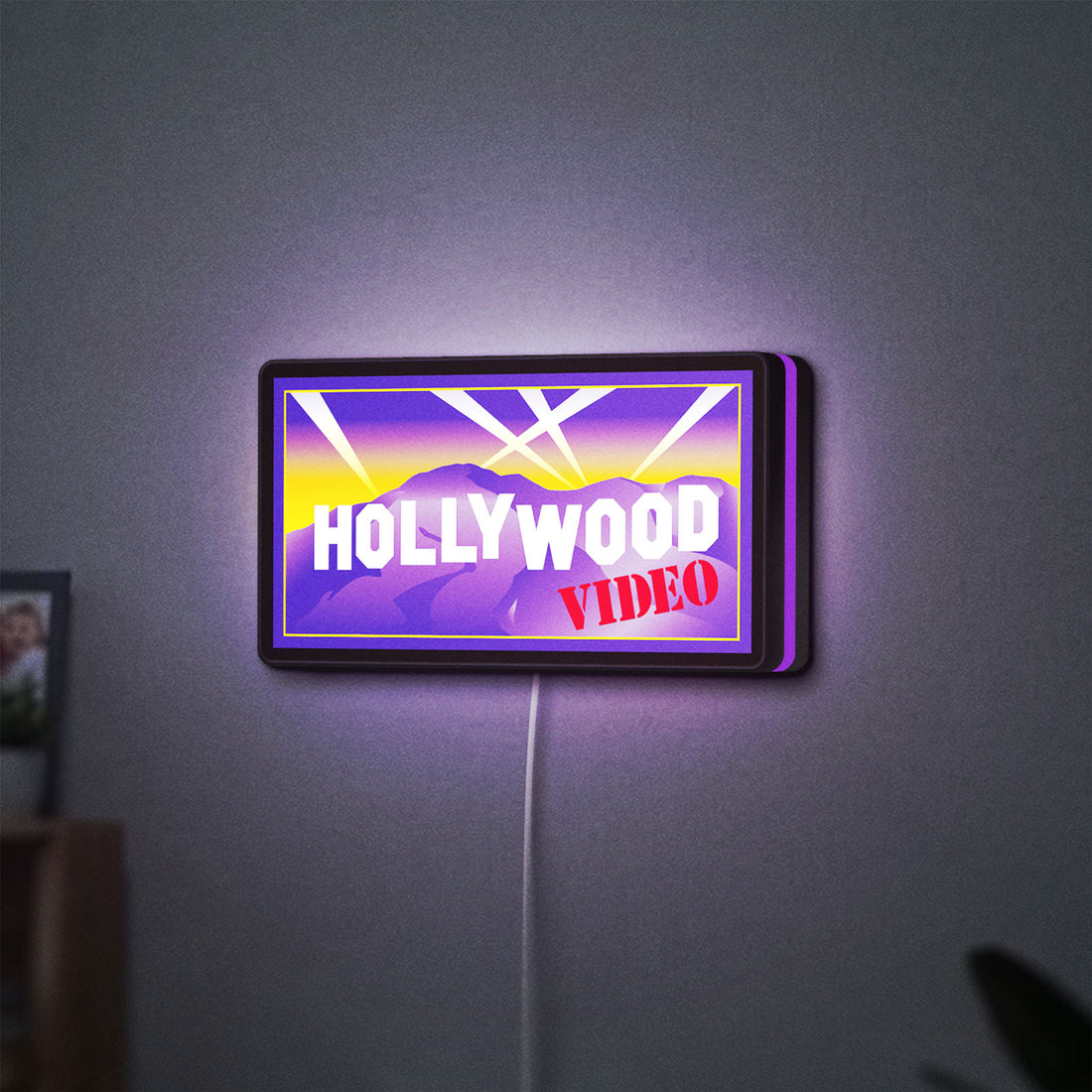 Hollywood Video LED lightbox hanging on a wall with purple glow