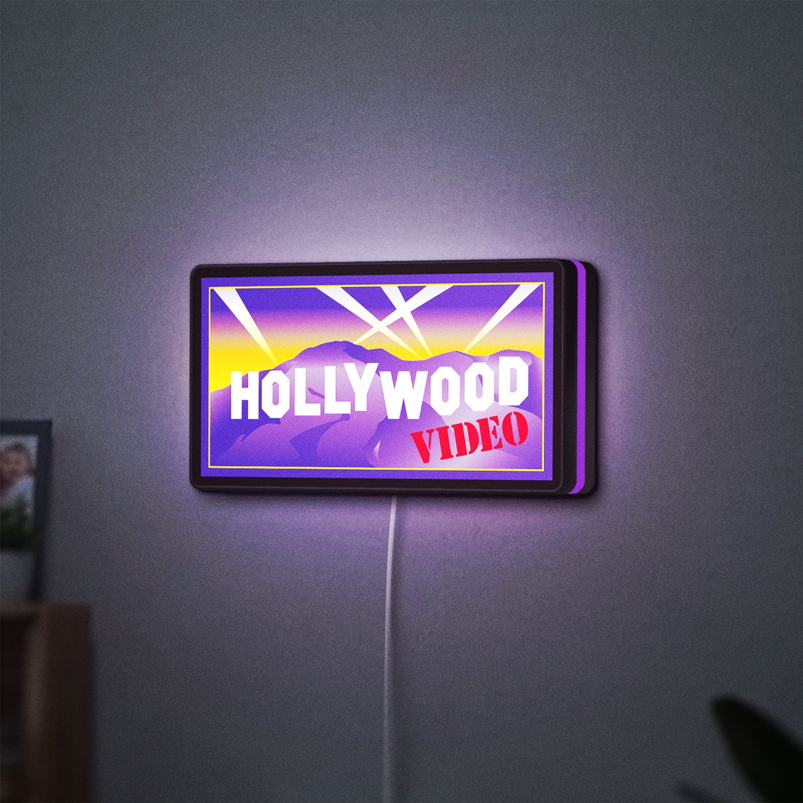 Hollywood Video LED lightbox hanging on a wall with purple glow