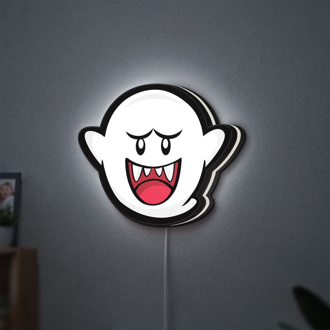 Boo LED lightbox hanging on a wall with white glow