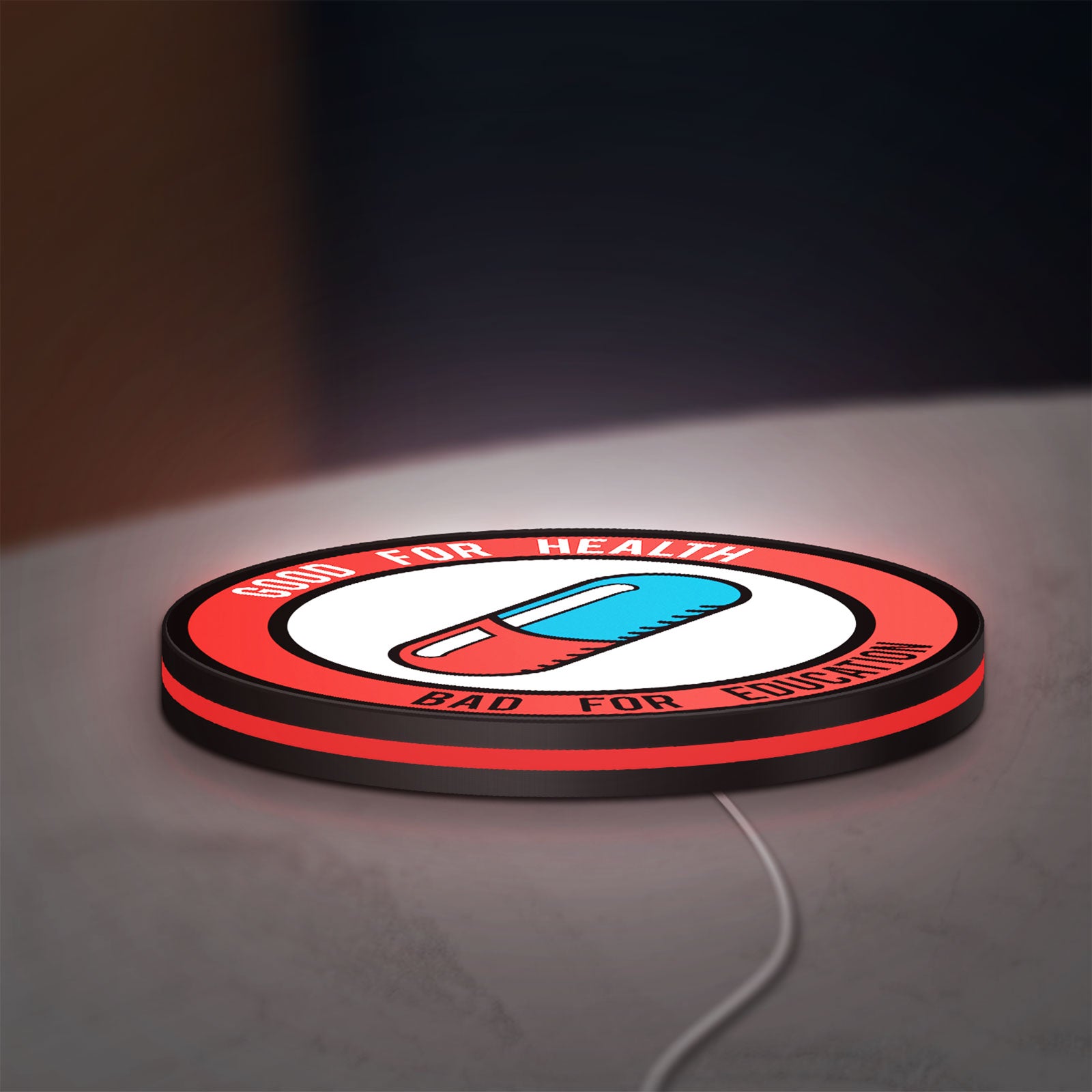 Akira Patch LED lightbox lying flat on a desk with red glow