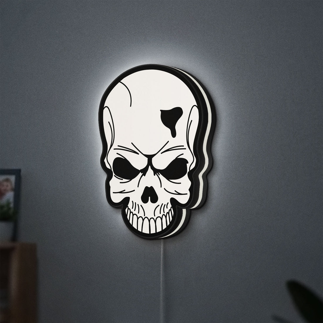 Skull LED lightbox hanging on a wall with white glow