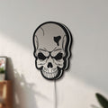 Unlit Skull LED lightbox mounted on a wall in daylight