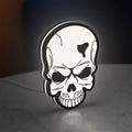 Skull LED lightbox standing on a desk from an angled side view with white glow
