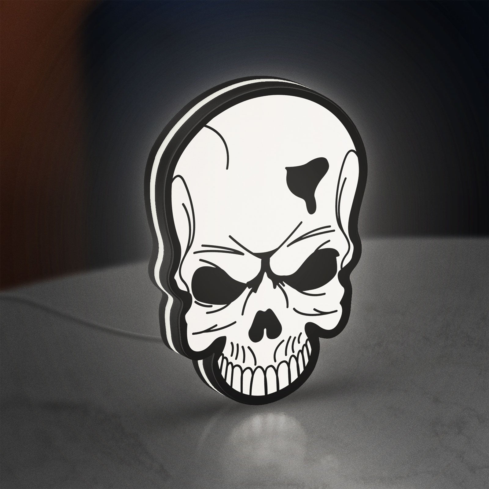 Skull LED lightbox standing on a desk from an angled side view with white glow