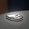 Skull LED lightbox lying flat on a desk with white glow