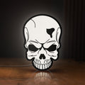 Front view of Skull LED lightbox sign glowing on a wooden desk