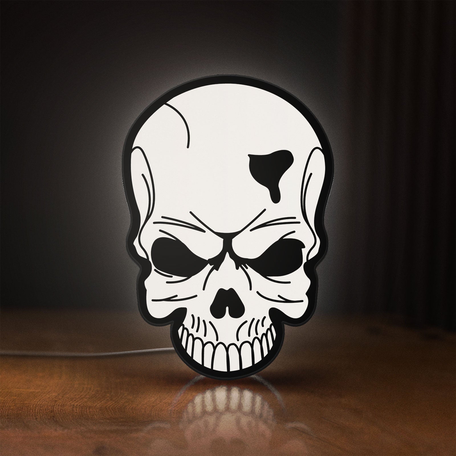 Front view of Skull LED lightbox sign glowing on a wooden desk