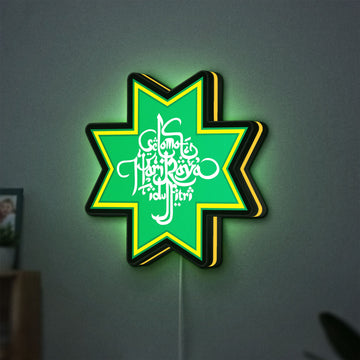 Selamat Idulfitri LED lightbox hanging on a wall with yellow glow