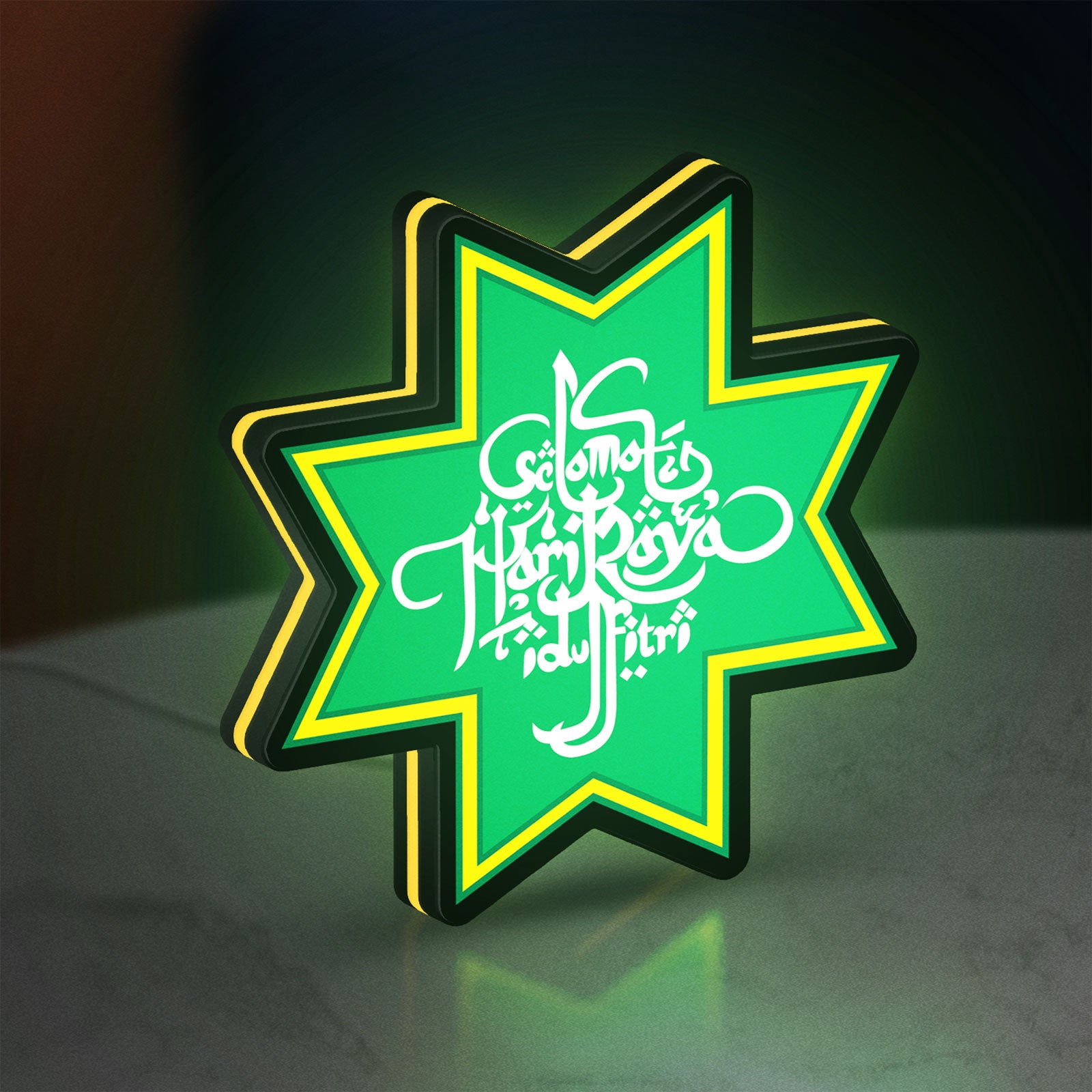 Selamat Idulfitri LED lightbox standing on a desk from an angled side view with yellow glow