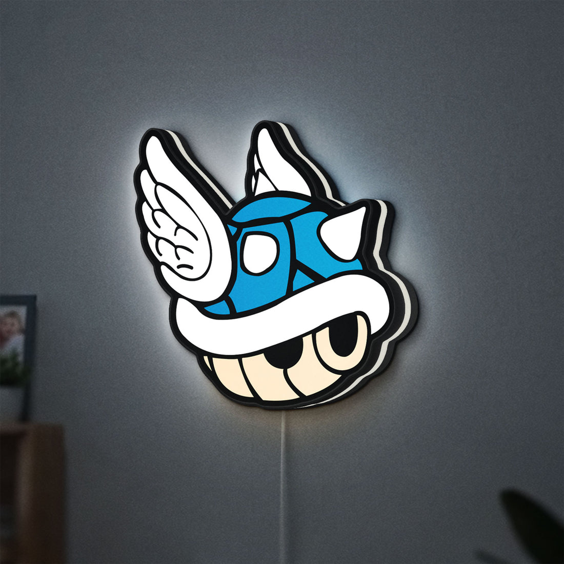 Blue Shell LED lightbox hanging on a wall with white glow