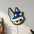 Unlit Blue Shell LED lightbox mounted on a wall in daylight