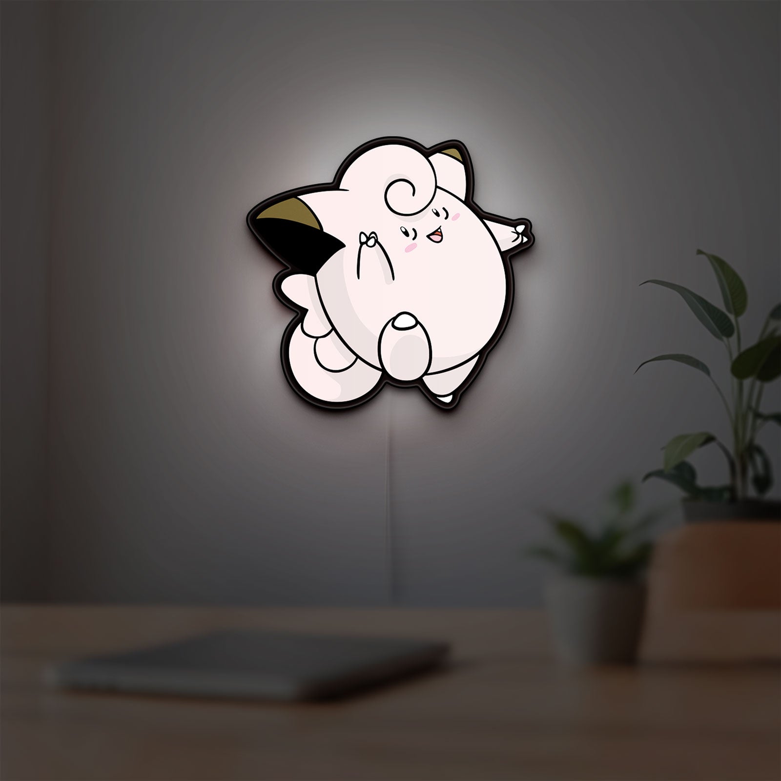 Clefairy LED lightbox hanging on a room wall with soft white light
