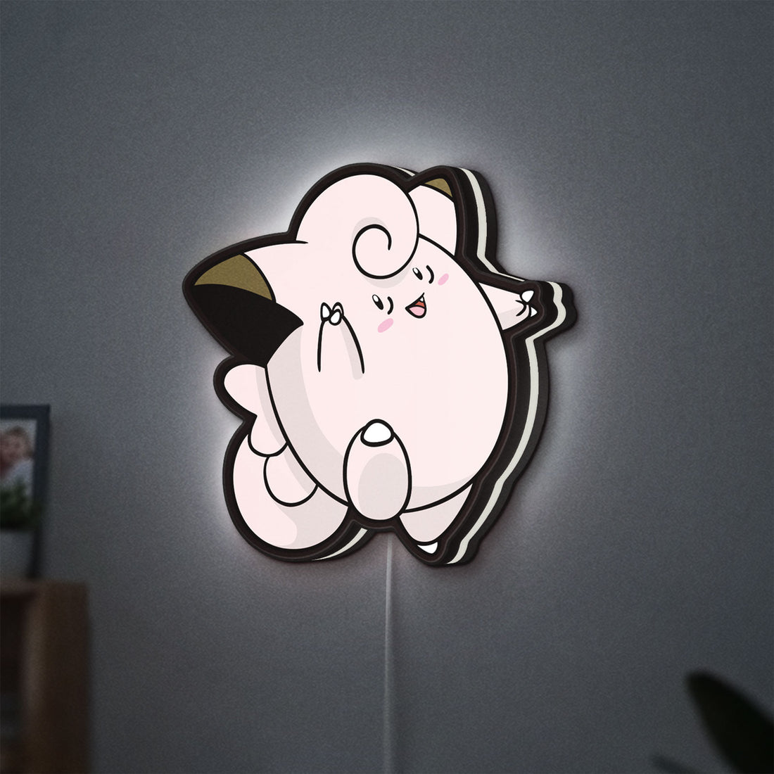 Clefairy LED lightbox hanging on a wall with white glow