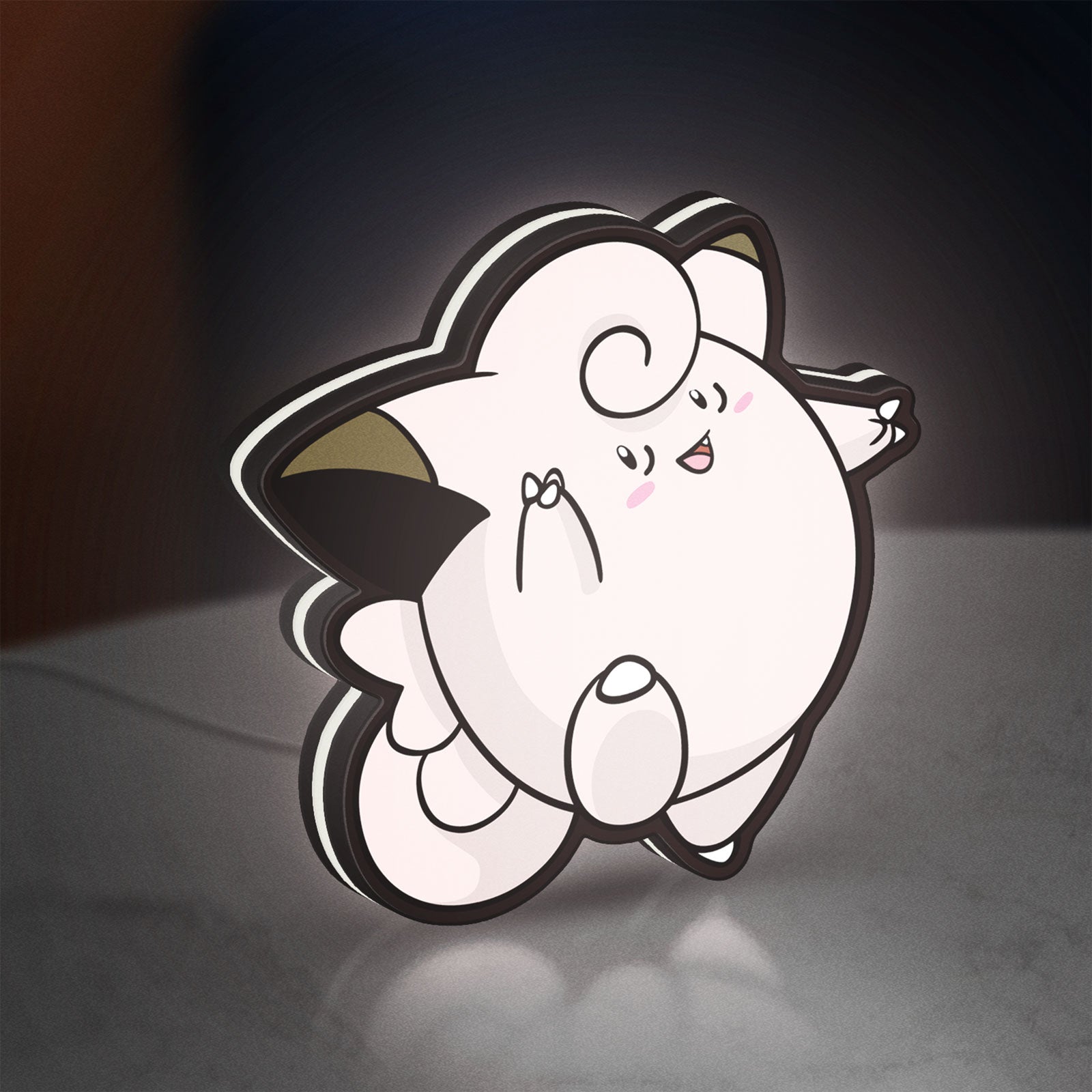 Clefairy LED lightbox standing on a desk from an angled side view with white glow