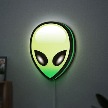 Alien LED lightbox hanging on a wall with green glow