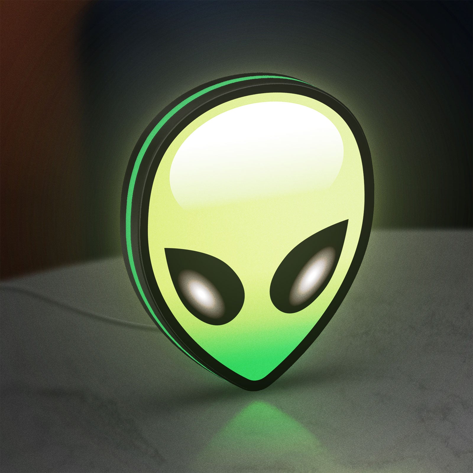 Alien LED lightbox standing on a desk from an angled side view with green glow