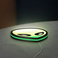 Alien LED lightbox lying flat on a desk with green glow