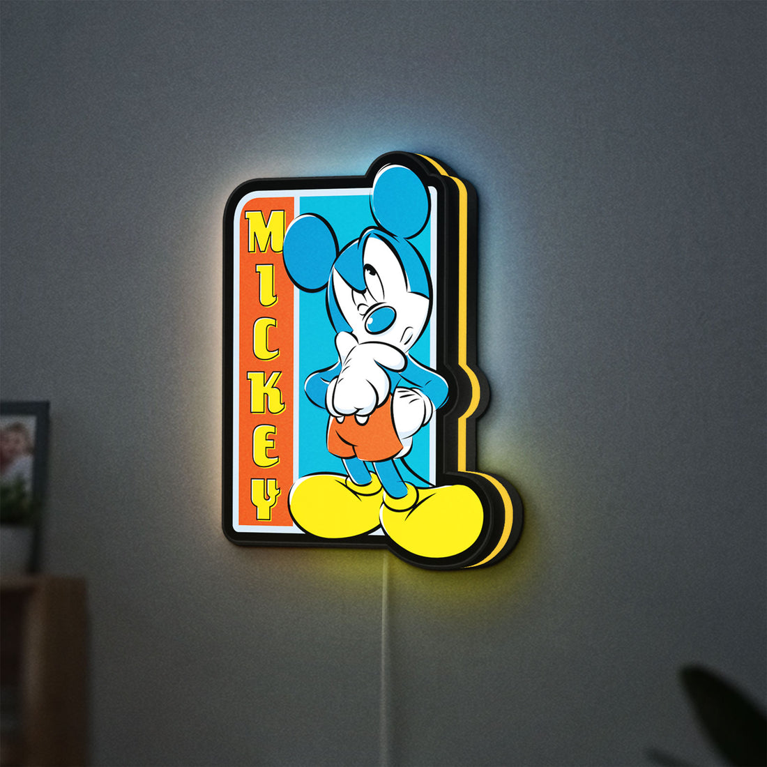 Mickey Mouse LED lightbox hanging on a wall with yellow glow