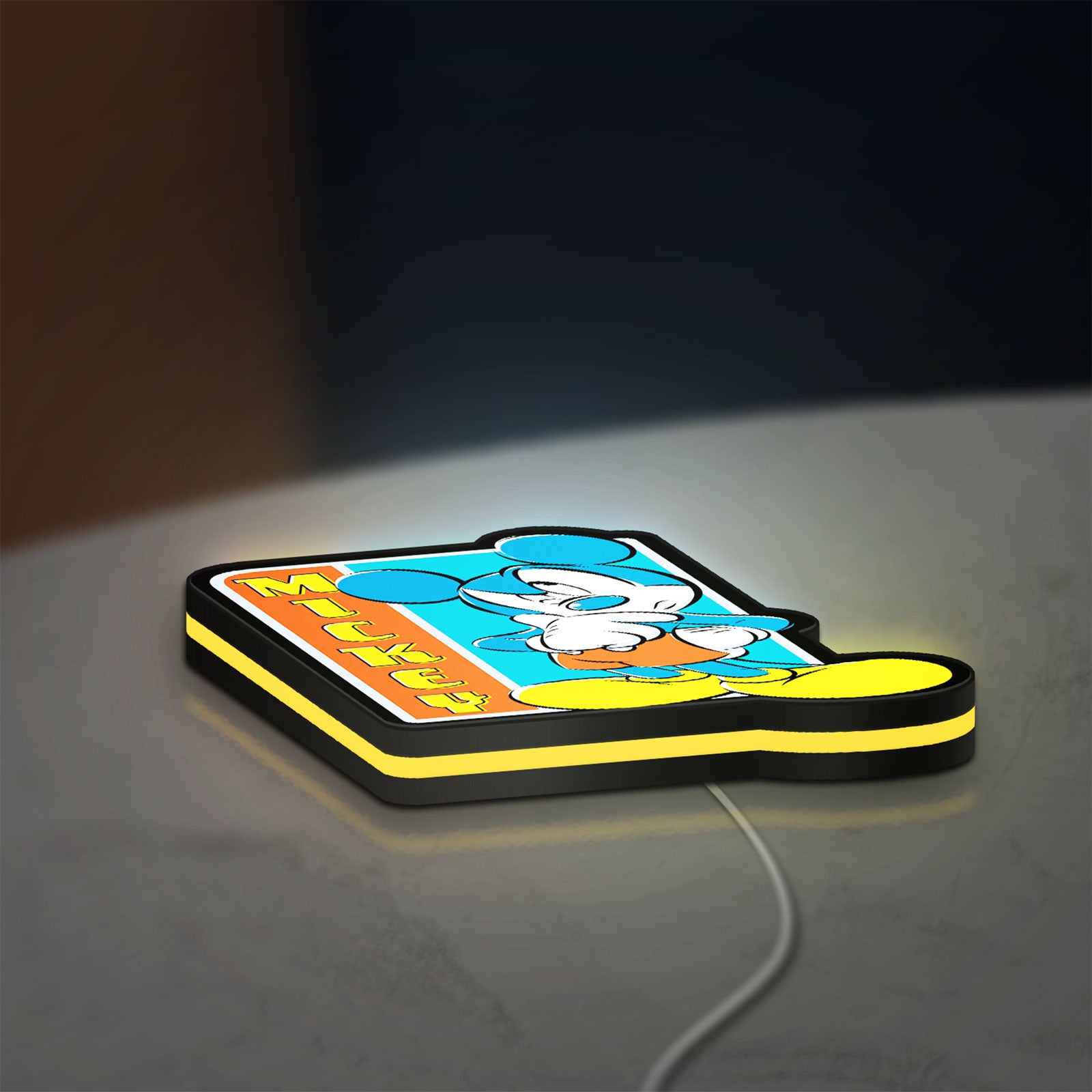 Mickey Mouse LED lightbox lying flat on a desk with yellow glow