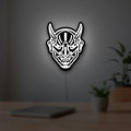 Japanese Hannya Mask LED lightbox hanging on a room wall with soft white light