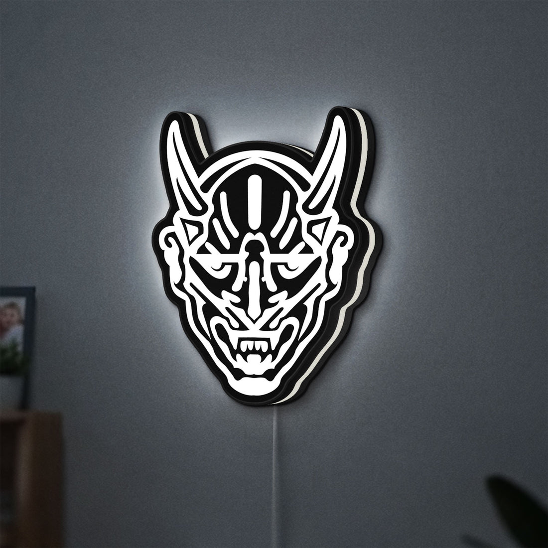 Japanese Hannya Mask LED lightbox hanging on a wall with white glow