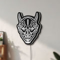 Unlit Japanese Hannya Mask LED lightbox mounted on a wall in daylight