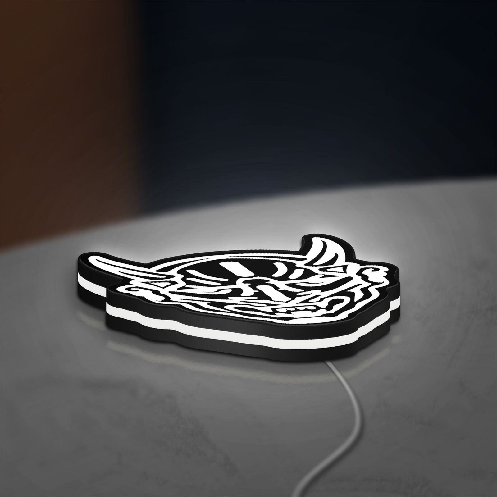 Japanese Hannya Mask LED lightbox lying flat on a desk with white glow
