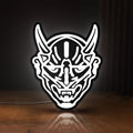 Front view of Japanese Hannya Mask LED lightbox sign glowing on a wooden desk