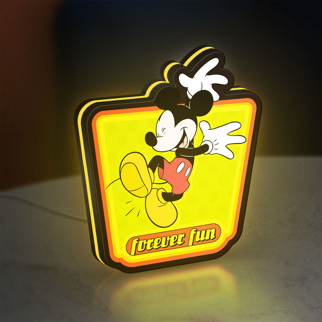 Mickey Mouse LED lightbox hanging on a wall with yellow glow