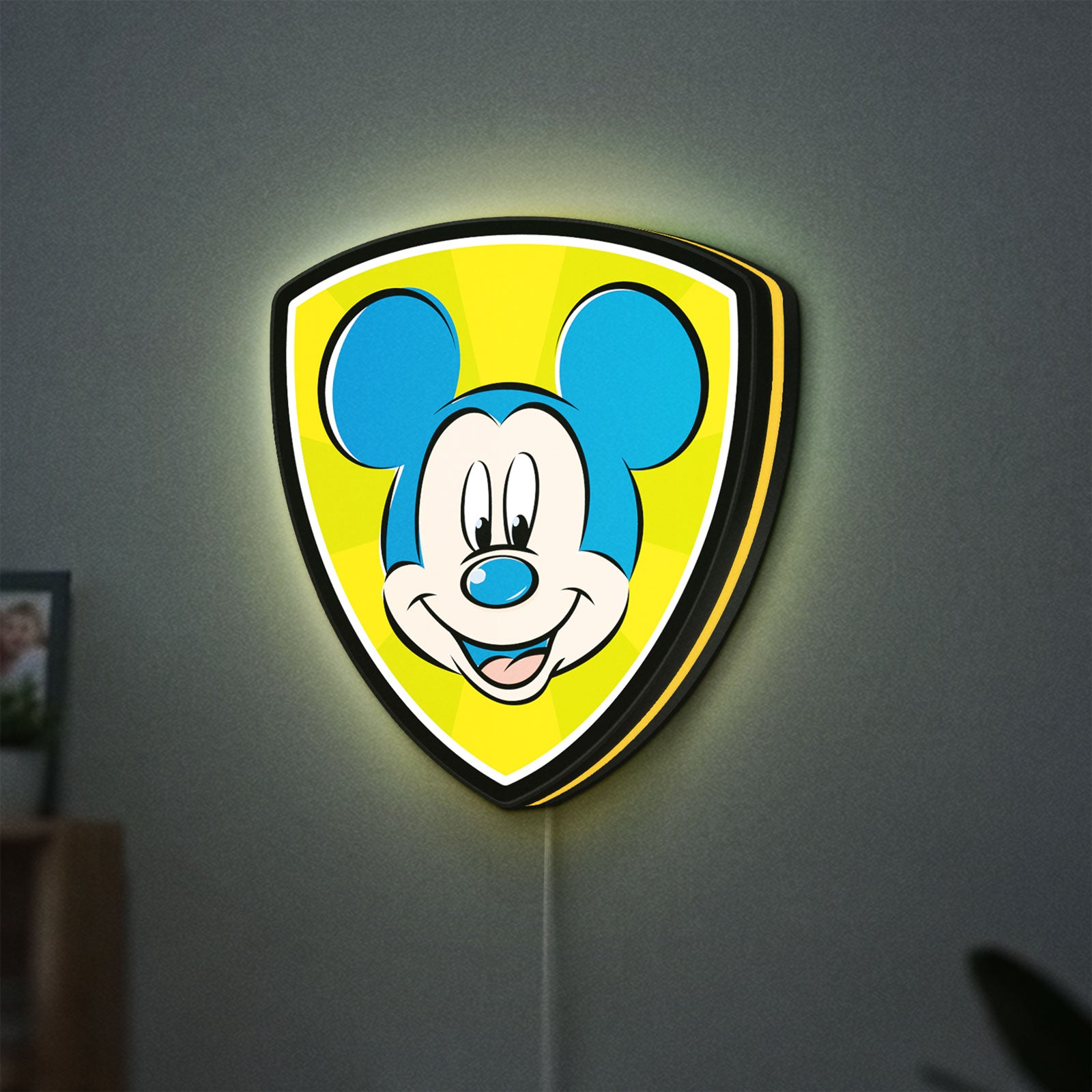 Mickey Mouse LED lightbox hanging on a wall with yellow glow