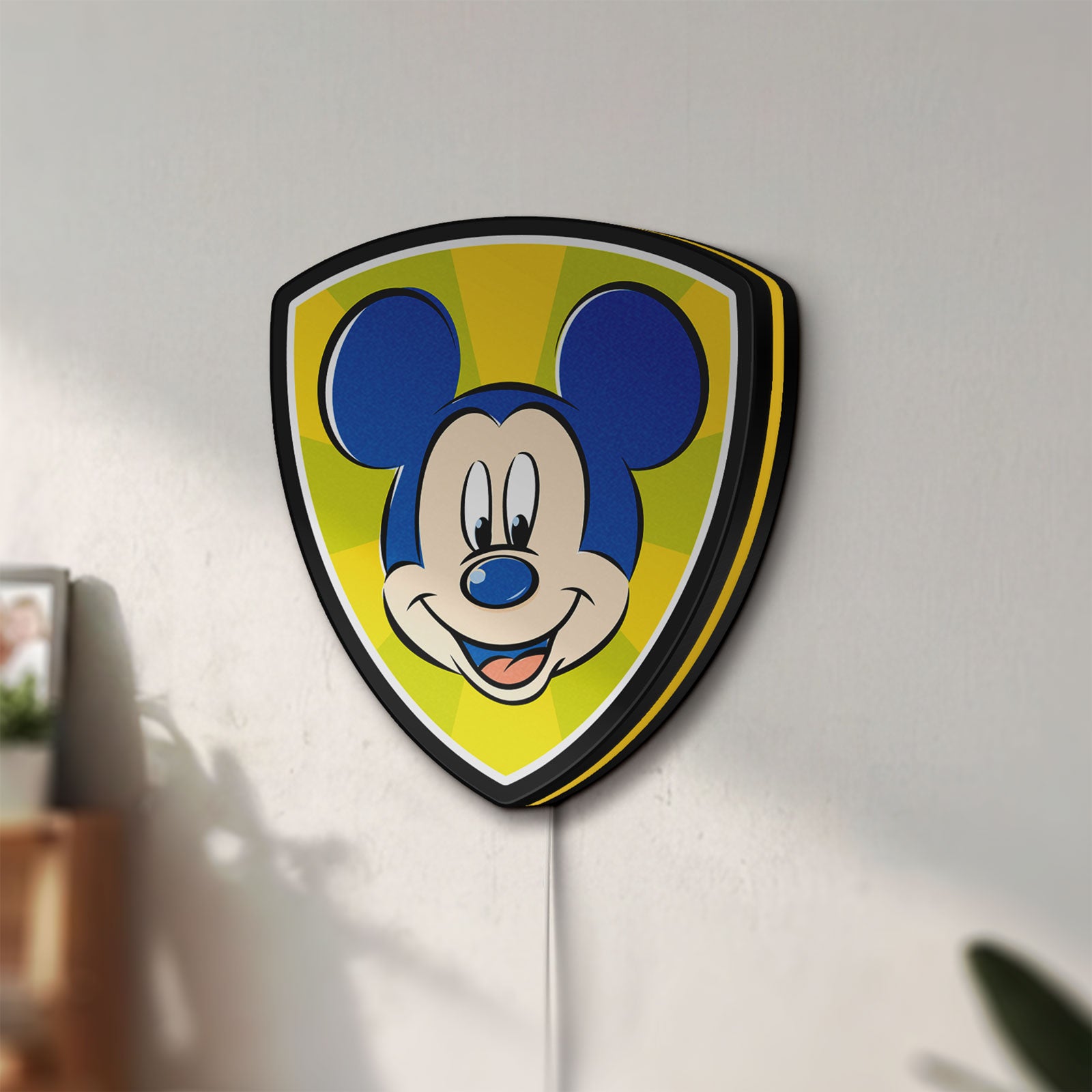 Unlit Mickey Mouse LED lightbox mounted on a wall in daylight